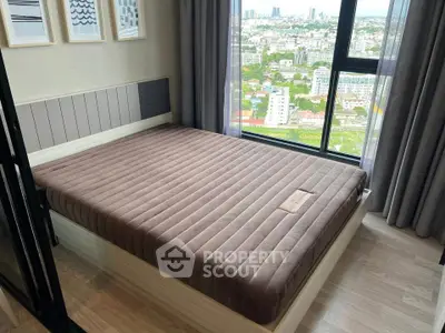 Modern bedroom with large window offering stunning city view, featuring a comfortable bed and stylish decor.