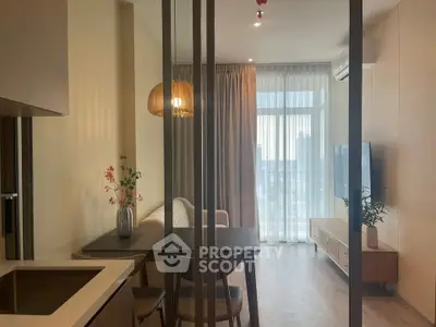 Modern living room with open kitchen, stylish decor, and large window offering city view.