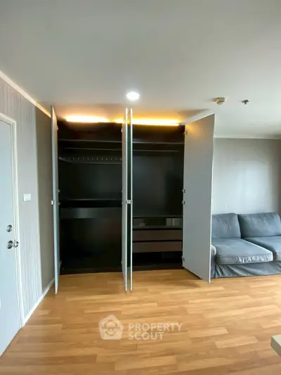 Spacious living room with modern open closet and cozy sofa