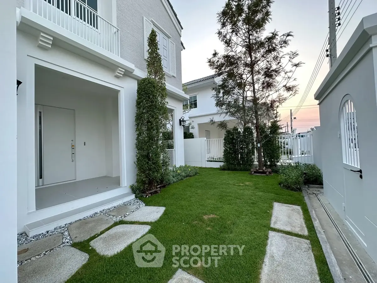 Charming modern home exterior with lush green lawn and elegant white facade