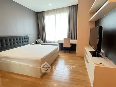 Modern bedroom with wooden flooring, large window, and sleek furniture design.