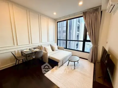 Modern living room with large windows and elegant decor in a high-rise apartment.
