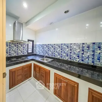 Modern kitchen with stylish mosaic backsplash and wooden cabinets