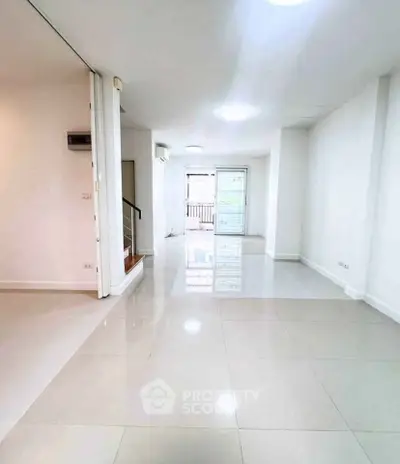 Spacious modern living area with glossy tiled floors and ample natural light.