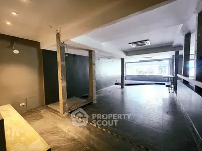 Spacious commercial interior with modern design and large windows for natural light.