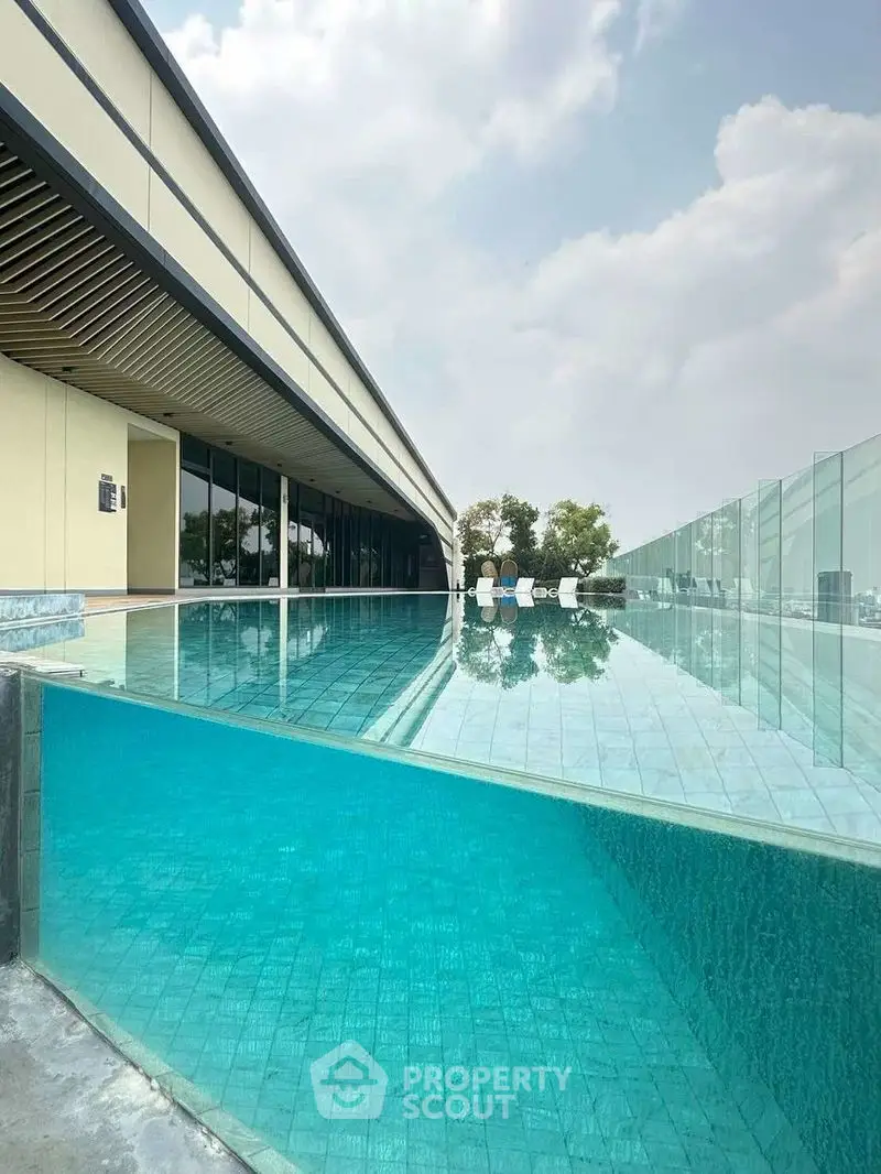 Luxurious rooftop infinity pool with glass walls and stunning city views.