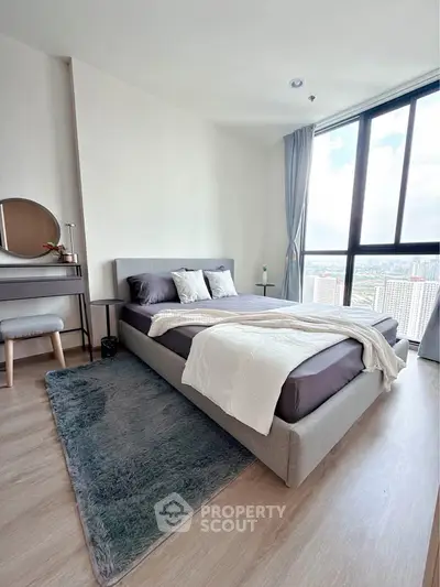 Modern bedroom with large windows and stylish decor in high-rise apartment.