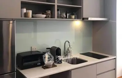 Modern kitchen with sleek cabinetry and appliances, featuring a minimalist design.