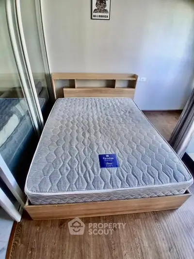 Cozy bedroom with modern bed and wooden flooring, ideal for restful nights.