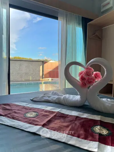 Luxurious bedroom with pool view and elegant towel swan decoration