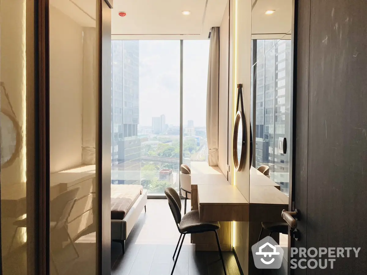 Sunlit modern apartment with floor-to-ceiling windows offering a panoramic city view, sleek furnishings, and a spacious layout.