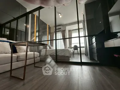 Modern bedroom with glass partition and sleek furnishings, featuring a cozy bed and stylish decor.