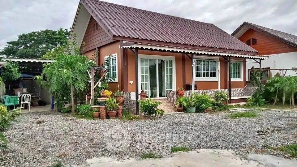 Charming single-story home with lush garden and gravel driveway, perfect for serene living.