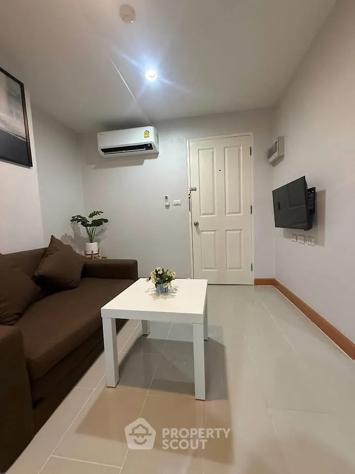 Cozy living room with modern air conditioning and wall-mounted TV, perfect for relaxation.