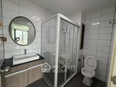 Modern bathroom with glass shower enclosure and sleek vanity in urban apartment