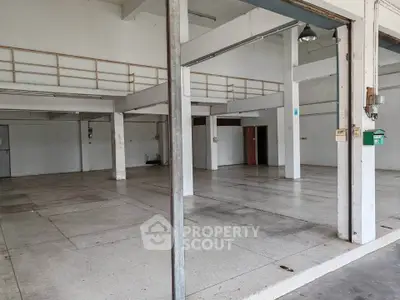 Spacious industrial-style open space with high ceilings and mezzanine, ideal for creative studio or warehouse.