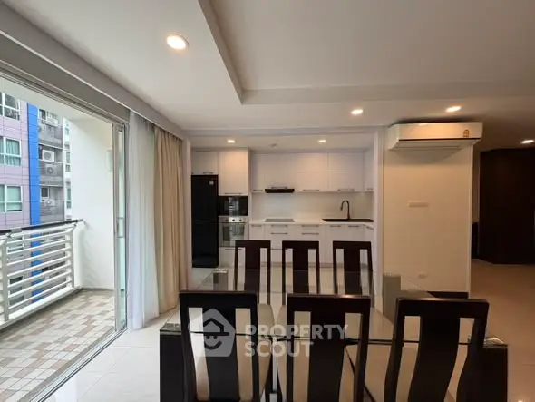 Modern open-layout kitchen and dining area with balcony access in a stylish apartment.