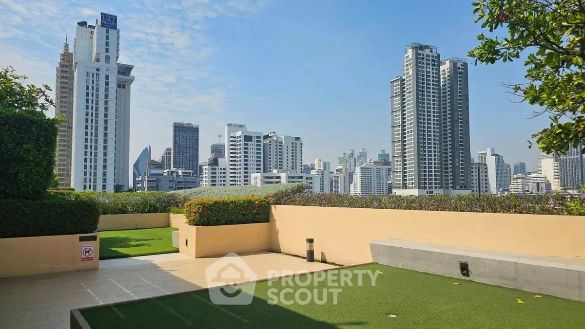 Stunning rooftop view of city skyline with lush greenery and modern architecture.