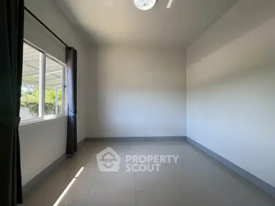 Spacious empty room with large window and natural light