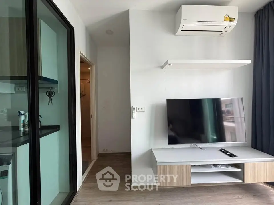 Modern living room with air conditioning and flat-screen TV, featuring sleek design and natural light.