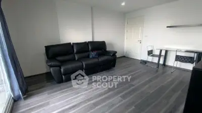 Modern living room with sleek flooring and stylish black leather sofa