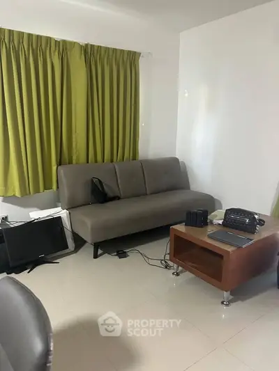 Cozy living room with modern sofa and green curtains, perfect for relaxation.