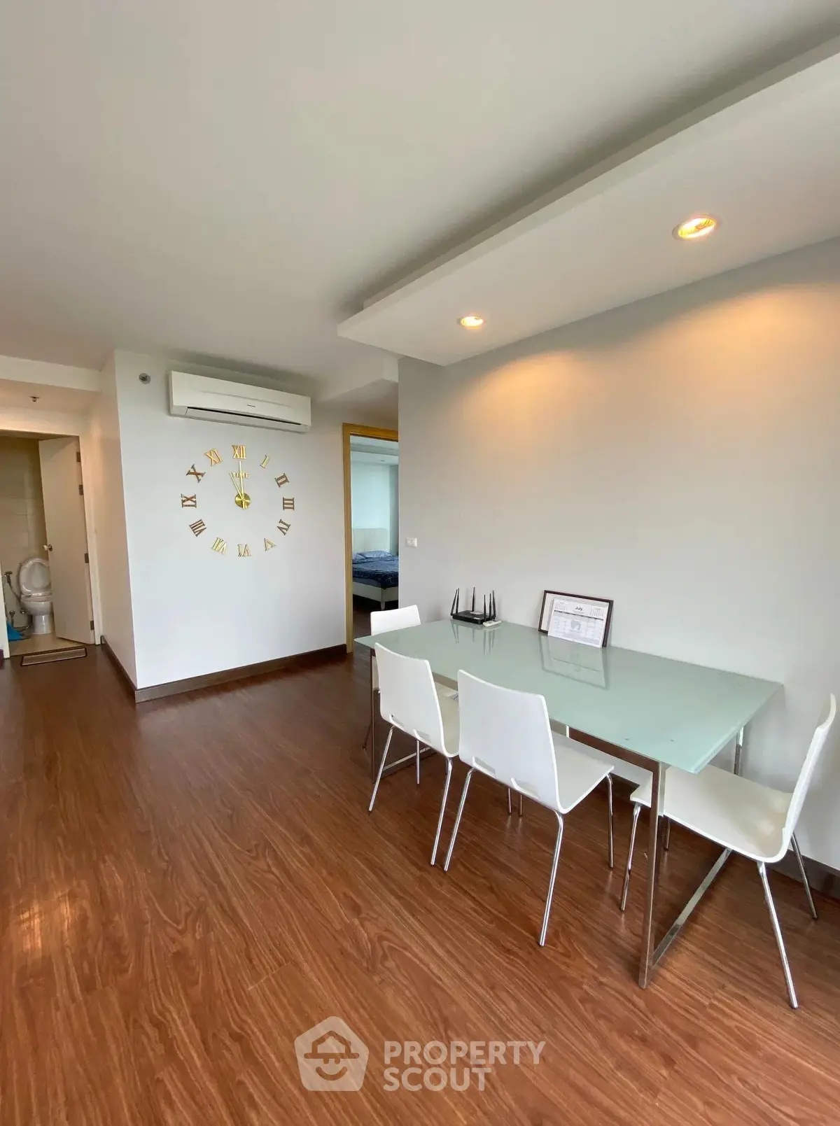 Modern dining area with glass table and white chairs in a stylish apartment