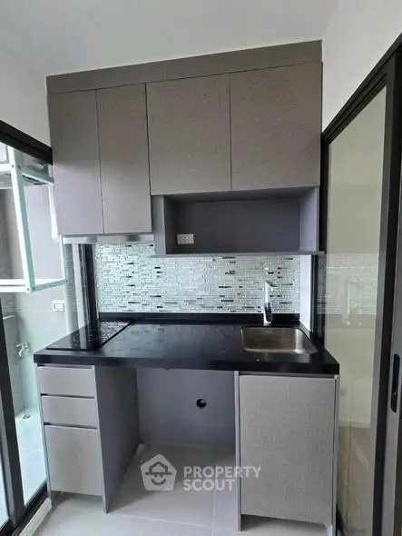 Modern compact kitchen with sleek cabinetry and stylish backsplash