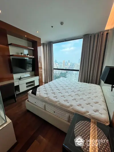 Luxurious bedroom with city view in high-rise apartment, featuring modern decor and large window.