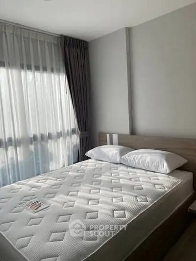 Modern bedroom with natural light and stylish decor in a real estate property.