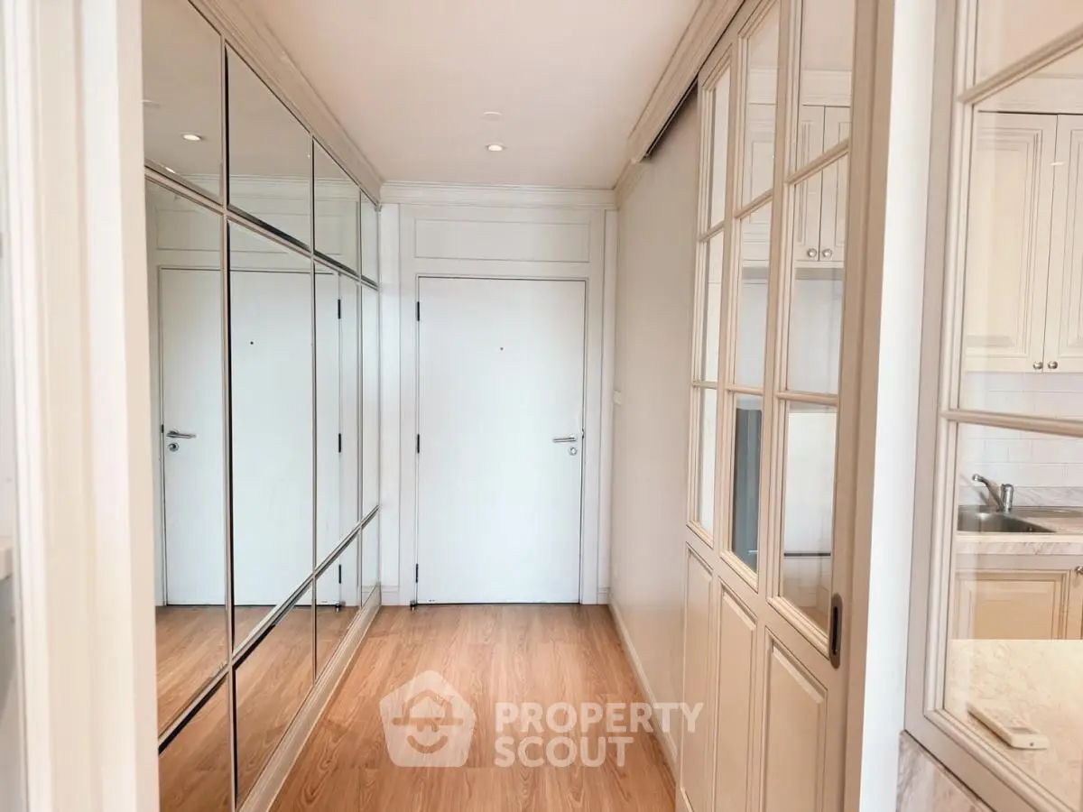 Elegant hallway with mirrored closets and wooden flooring in modern apartment