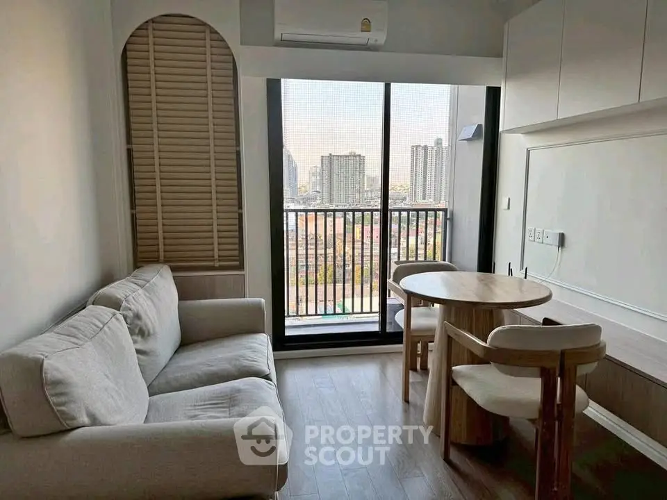 Modern living room with city view, cozy sofa, and dining area in a high-rise apartment.