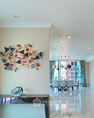 Luxurious open-plan living and dining area with modern art and elegant lighting.