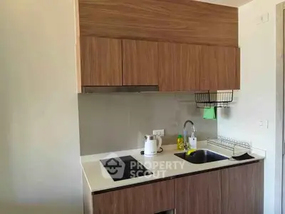 Modern compact kitchen with wooden cabinets and sleek appliances.