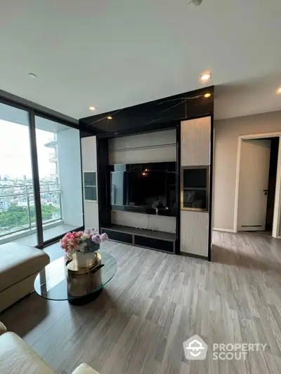 Modern living room with large windows and city view, featuring sleek TV unit and stylish decor.