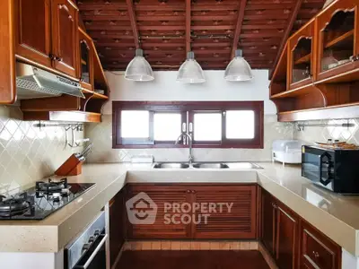 Charming rustic kitchen with wooden cabinets and modern appliances, featuring a gas stove and ample natural light.