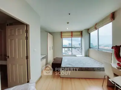 Spacious bedroom with large windows offering stunning city views and modern furnishings.