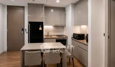 Modern kitchen with sleek cabinetry and dining area in contemporary apartment
