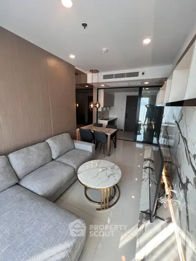 Modern living room with marble accents and open kitchen layout