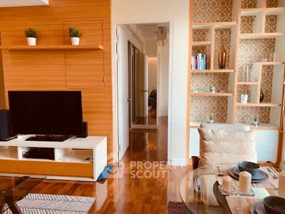 Stylish living room with modern decor and wooden accents, featuring a TV and elegant shelving.