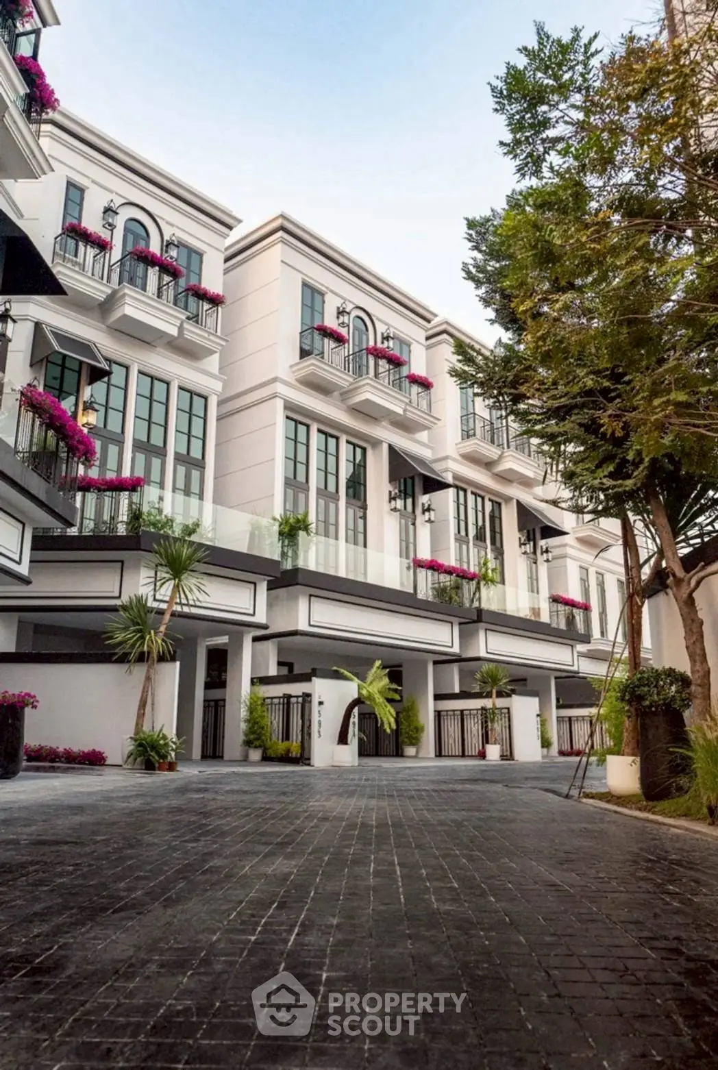 Elegant modern townhouse exterior with lush landscaping and balconies, perfect for luxury urban living.