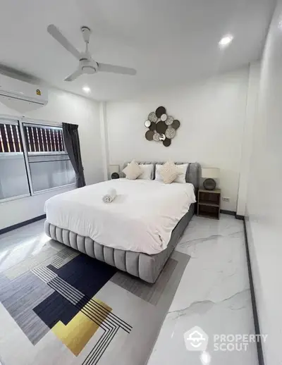 Modern bedroom with stylish decor and large bed in a bright, airy space.