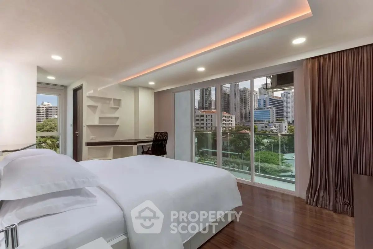 Luxurious bedroom with city view and modern decor, featuring floor-to-ceiling windows and elegant furnishings.