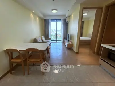Modern living room with open layout and city view, featuring cozy furniture and natural light.