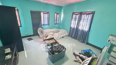 Spacious living room with teal walls and natural light, featuring potential for customization.