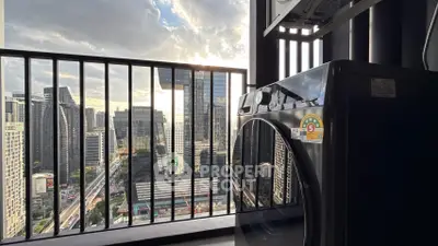 Modern high-rise balcony with city view and washing machine, perfect urban living.