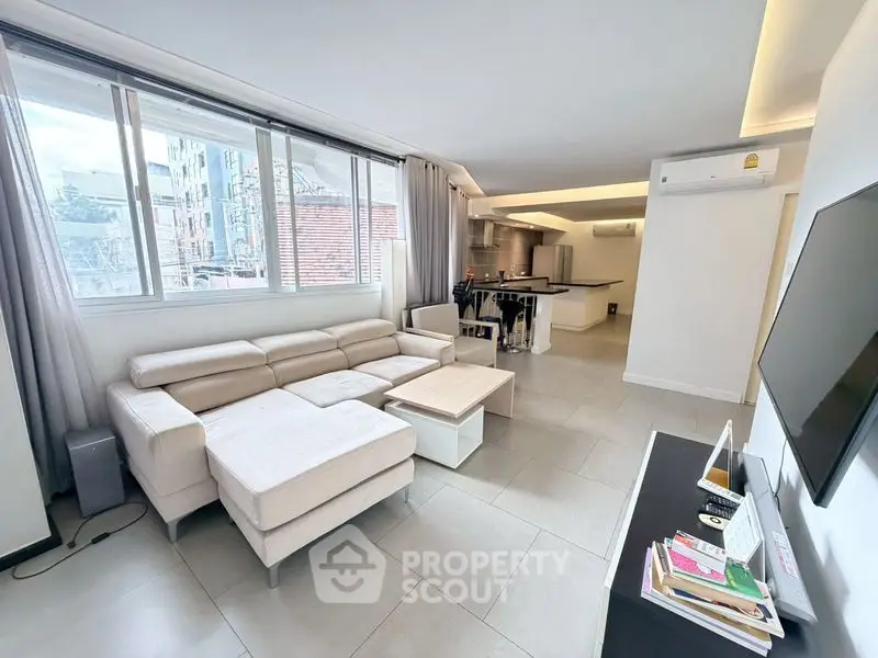 Spacious modern living room with open kitchen and large windows