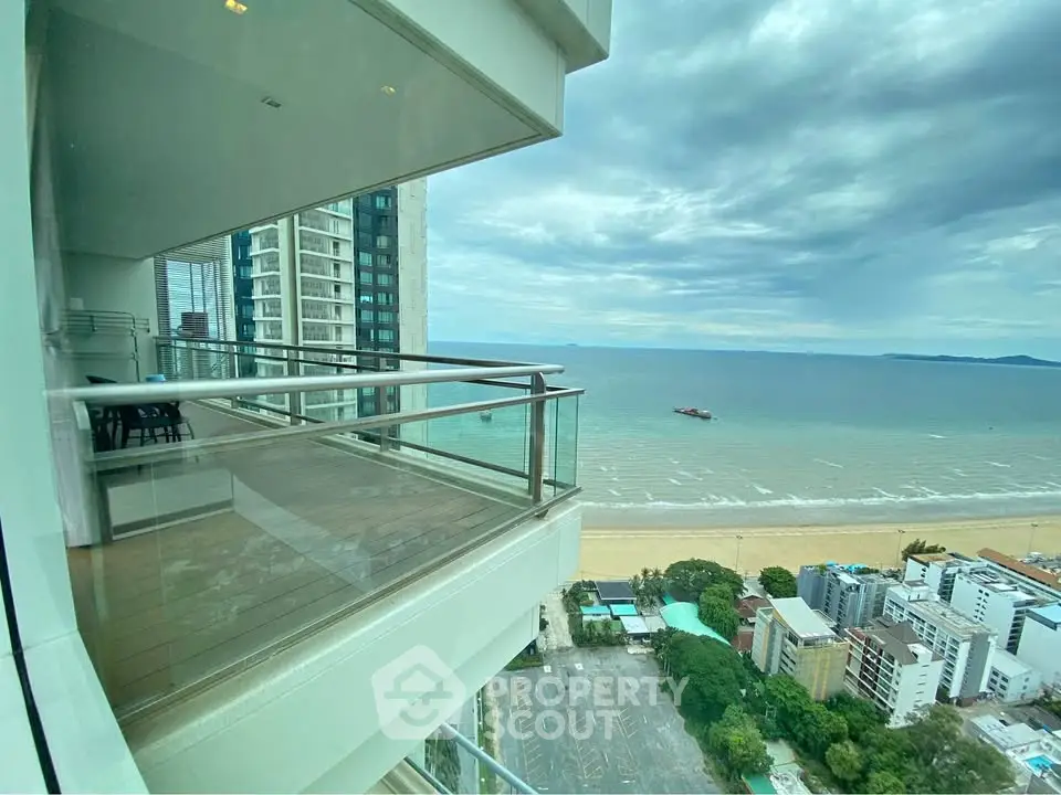 Stunning ocean view from high-rise balcony in luxury beachfront apartment.