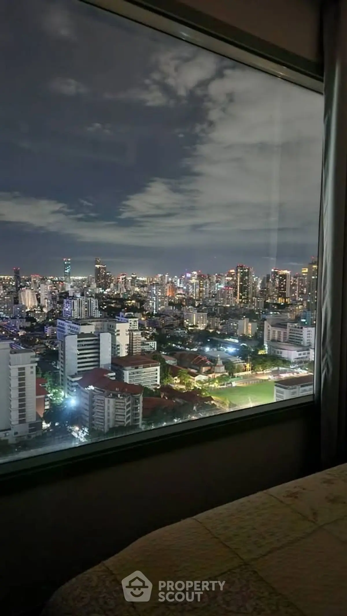 Stunning cityscape view from high-rise apartment window at night.