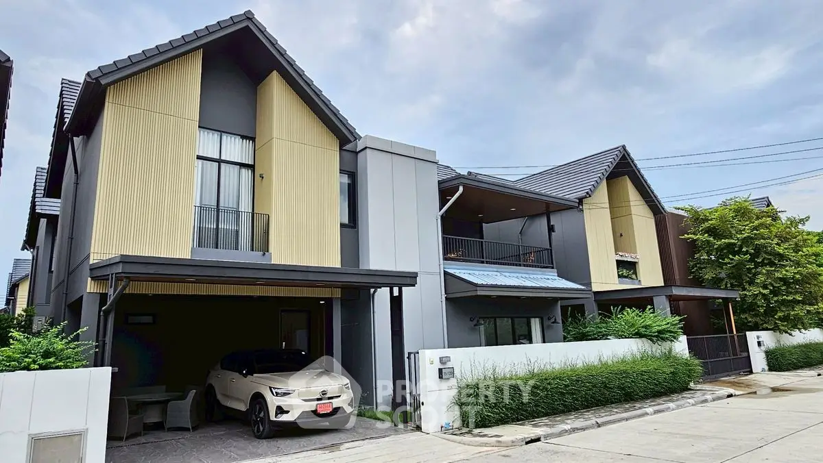 Modern two-story house with sleek design and spacious driveway in a suburban neighborhood.